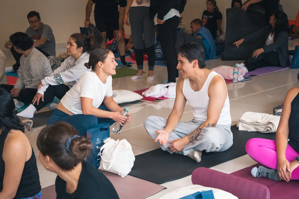 Two participants seated on mats talking at a previous Resetea session